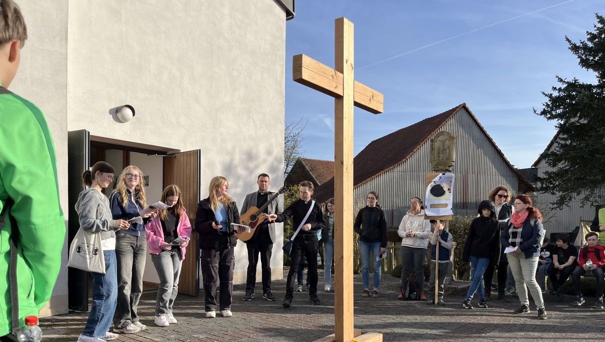 Jugendliche vor der Kirche in Dittlofrod bei der letzten Station des ökumenischen Kreuzweges