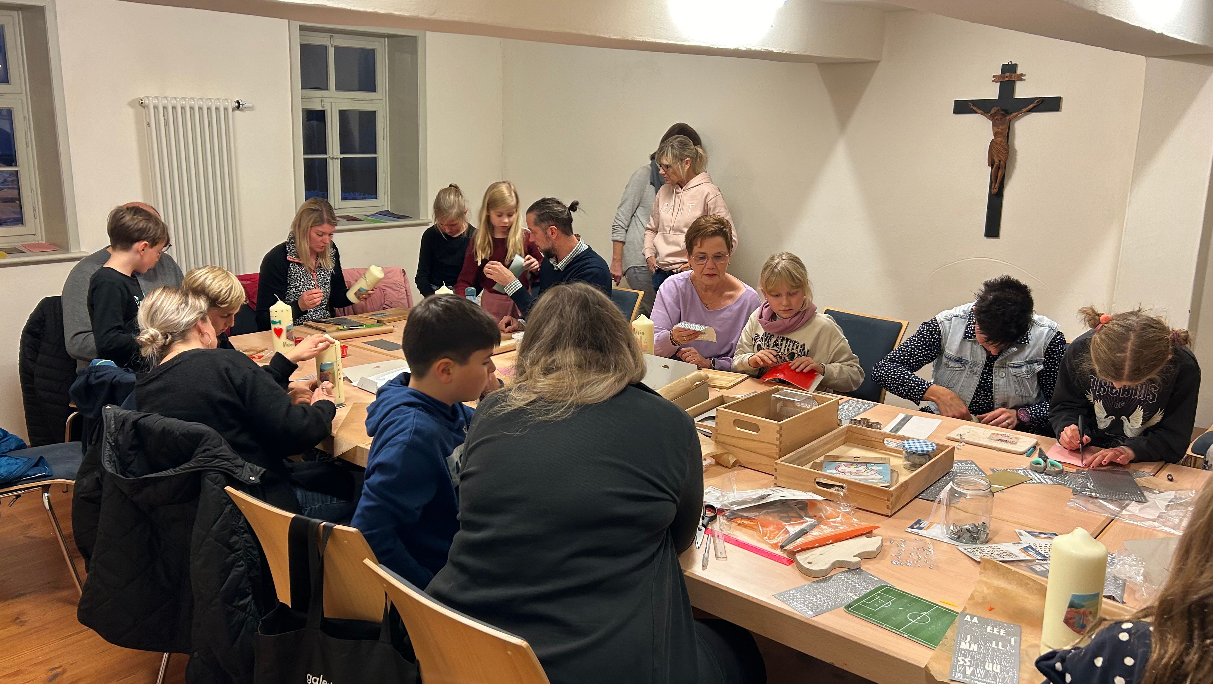 Erstkommunionkinder mit ihren Eltern beim Basteln der Familienkerze