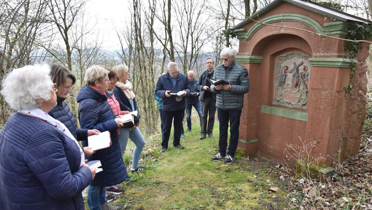 Mehrere Personen beten den Kreuzweg am Gehilfersberg