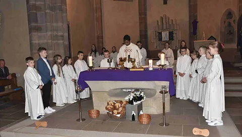 Erstkommunionkinder stehen am Altar vor dem Empfang der ersten Heiligen Kommunion
