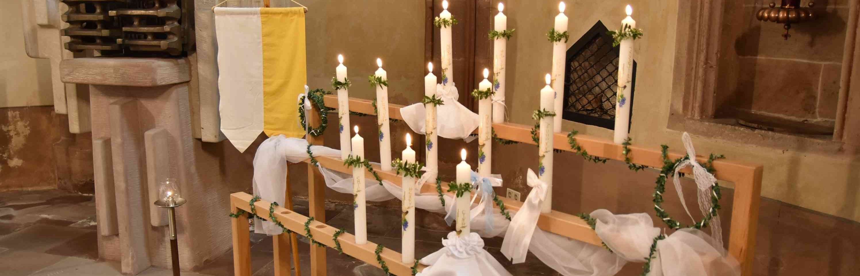 Kerzenständer mit brennenden Erstkommunionkerzen